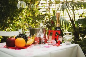 Фото Свидание в оранжерее, столик для двоих, свечи, фрукты, шампанское