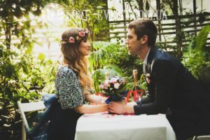 Фото Двое влюбленных молодоженов на свидании в оранжерее, свечи, шампанское